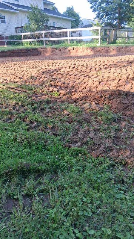 Pool excavation along the yard edge beside a house and fence in Stoneville